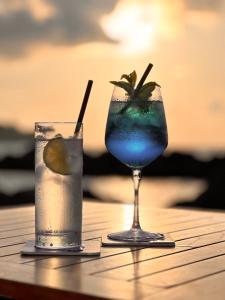 two cocktails sitting on a wooden table at Pagoda Lifestyle Hotel in Ischia