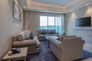 Jood Hotel Apartments في دبي: غرفة معيشة مع كنبتين وتلفزيون بشاشة مسطحة