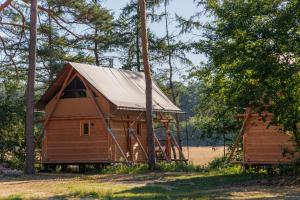 eine große Holzhütte mit Metalldach in der Unterkunft Huttopia De Meinweg in Herkenbosch