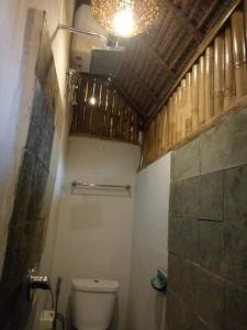 La salle de bains est pourvue de toilettes et d'une douche au plafond. dans l'établissement Candra Surf Homestay, à Canggu