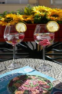 two glasses of wine with lemon slices in them on a table at Charming Lisbon Central Apartment in Lisbon