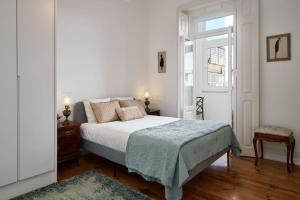 a white bedroom with a bed and a window at Charming Lisbon Central Apartment in Lisbon
