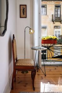 una silla y una mesa en una habitación con ventana en Charming Lisbon Central Apartment en Lisboa