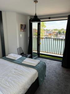 a bedroom with a bed and a large window at Duplex Apartment Harbourside city centre in Bristol