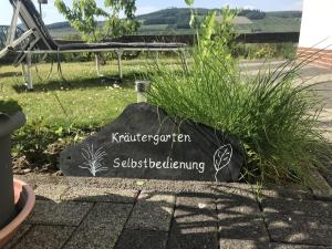 un cartel en una roca en un jardín en FeWo Oase Ruhrtalblick en Bestwig