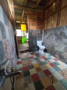 ein Bad mit WC und Fliesenboden in der Unterkunft Kebun Hanoman Villa in Pablengan