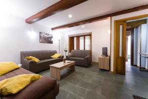 a living room with a bed and a couch and a tv at Casa D'Abaixo in Arzúa