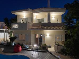 a large house at night with a swimming pool at Vila Luisa Anabela Piscine et Jacuzzi only family in Albufeira