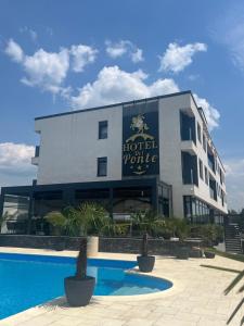 un hotel con piscina frente a un edificio en Hotel Del Ponte en Târgovişte