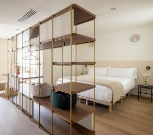1 dormitorio con cama y estante para libros en The Passage Apartments, en San Sebastián