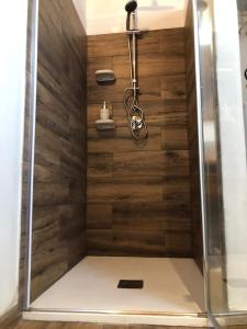 een douche met houten lambrisering in de badkamer bij Jess & Joe's in Castelvetrano Selinunte