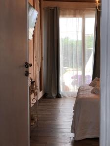 a bedroom with a bed and a large window at Jess & Joe's in Castelvetrano Selinunte