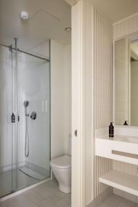 y baño con ducha, aseo y lavamanos. en The Passage Apartments, en San Sebastián