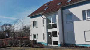 uma casa branca e azul com um telhado vermelho em Fewo65 Residenz am Strand em Zingst