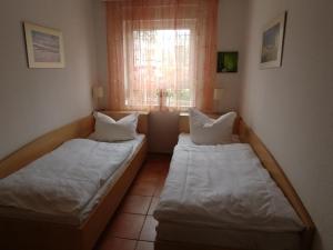 Duas camas num quarto com uma janela em Fewo65 Residenz am Strand em Zingst