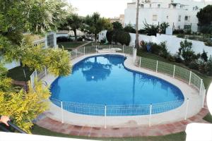 uitzicht over een groot blauw zwembad bij Apartamento Carlota beach carihuela in Torremolinos