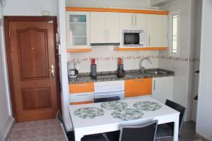 een kleine keuken met een tafel en een wastafel bij Apartamento Carlota beach carihuela in Torremolinos