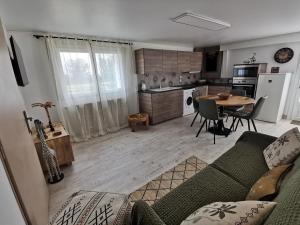 a living room with a couch and a table and a kitchen at Gîte - Chambres d'Hôtes La Belle Hélène in Bressuire