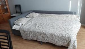 a bed with a gray comforter in a bedroom at 50m2 Cozy Apartment, FREE Parking 20 min to Center in Espoo