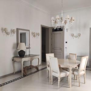 uma sala de jantar com uma mesa, cadeiras e um espelho em Carlo's rooms em Trapani