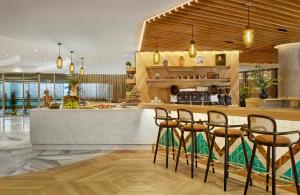 un restaurant avec un bar doté de chaises et d'un comptoir dans l'établissement Sheraton Amsterdam Airport Hotel and Conference Center, à Schiphol