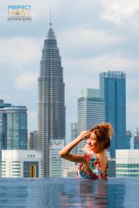 a woman standing in the water in the city at Ceylonz KLCC by Perfect Host in Kuala Lumpur