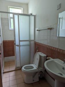 a bathroom with a toilet and a sink at Shiranthi Guest House in Rajagiriya