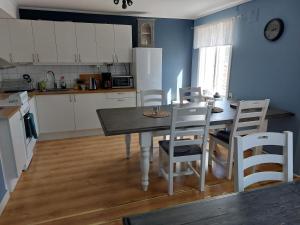 a kitchen with a table and chairs in a kitchen at Flora Dekor gästgård, Lenagården in Alingsås