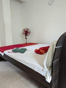 a bedroom with a bed with a fan on it at Shiranthi Guest House in Rajagiriya