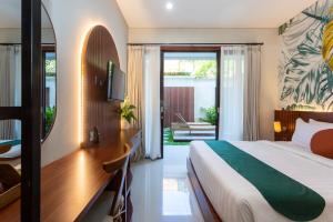 ein Hotelzimmer mit einem Bett, einem Schreibtisch und einem Schlafzimmer in der Unterkunft Cove Ransha Stay in Sanur