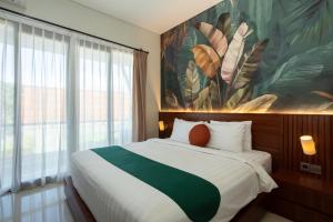 ein Schlafzimmer mit einem großen Bett mit einem Gemälde an der Wand in der Unterkunft Cove Ransha Stay in Sanur