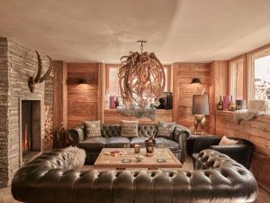 a living room with a leather couch and a table at Firefly Luxury Suites in Zermatt