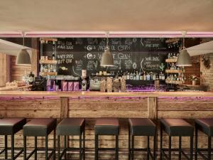 a bar with a chalkboard wall and stools at Firefly Luxury Suites in Zermatt