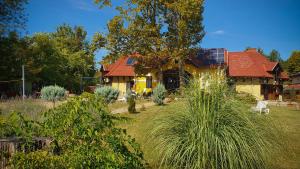 a house with a red roof and a yard with plants at Harmónia Apartmanház in Balatonlelle