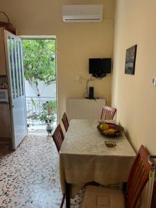 una sala da pranzo con tavolo e cesto di frutta di Traditional home in Mauromati a Mavrommátion