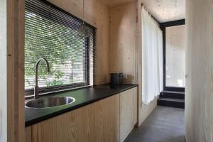 eine Küche mit einem Waschbecken und einem Fenster in der Unterkunft Buitenplaats Petersburg in Arnhem
