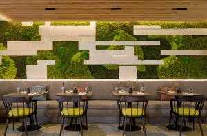 een restaurant met vier tafels en een groene muur bij Sheraton Amsterdam Airport Hotel and Conference Center in Schiphol