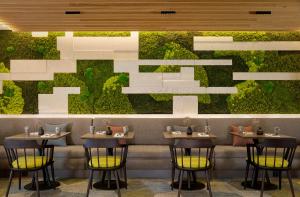 a restaurant with four tables and a green wall at Sheraton Amsterdam Airport Hotel and Conference Center in Schiphol