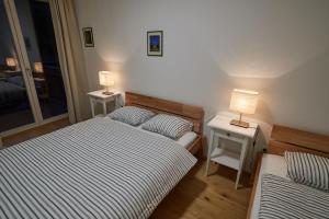 1 Schlafzimmer mit 2 Betten und 2 Tischen mit Lampen in der Unterkunft Kovárna Residence in Pec pod Sněžkou