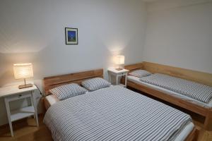 two beds in a room with two lamps on tables at Kovárna Residence in Pec pod Sněžkou