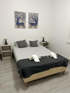 uma cama num quarto com três pinturas na parede em Oriente DNA Studios IV em Lisboa