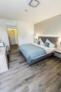a bedroom with a large bed and wooden floors at Hökis-Zimmervermietung 4 in Brande-Hörnerkirchen