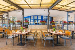 a restaurant with tables and chairs and flowers at Brijuni Hotel Neptun in Fažana