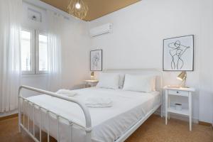 a white bedroom with a white bed and two tables at Breeze 1BD Apartment by BluPine in Athens