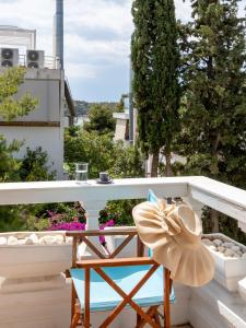 a hat sitting on a chair on a balcony at Breeze 1BD Apartment by BluPine in Athens