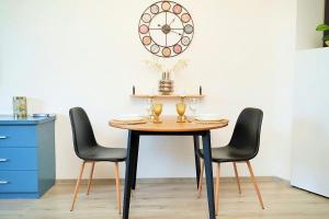 una mesa con tres sillas y un reloj en la pared en Design Studio in Atlantis Resort&SPA, Burgas Airport en Burgas