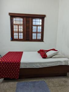 a bed sitting in a room with a window at Shiranthi Guest House in Rajagiriya
