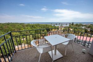 a table and chairs on a balcony with the ocean at Serenity by Oxygen Residence in Neptun