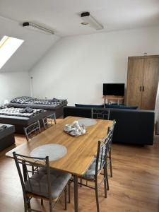 a dining room with a wooden table and chairs at Korzó Apartments in Dunajská Streda