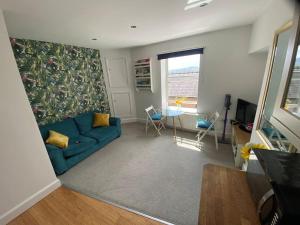 a living room with a blue couch and a table at Fabulous Flat close to Town & Countryside, Matlock in Matlock